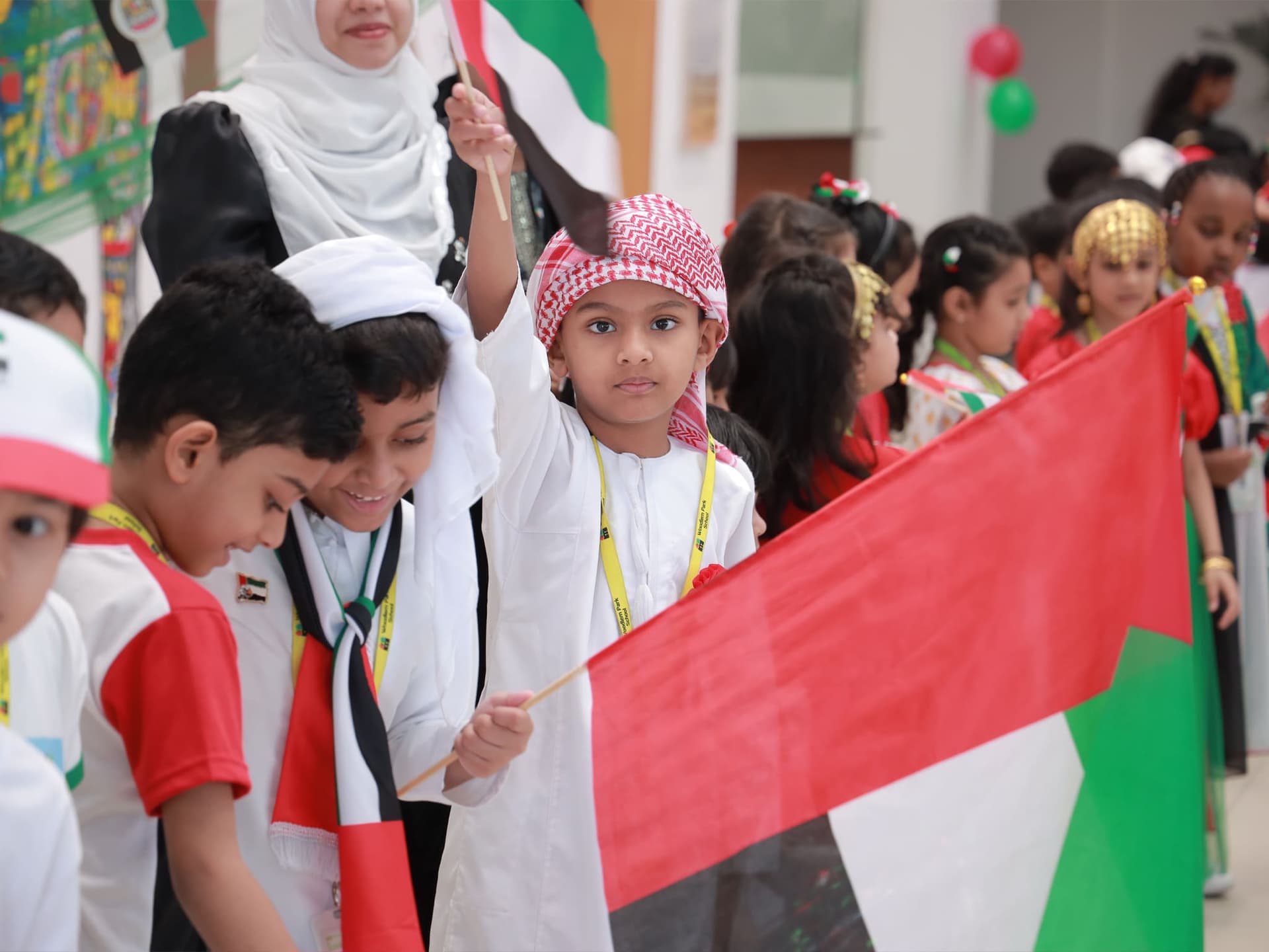 Students waving UAE flags during National Day celebrations at Woodlem Park School Hamidiya
