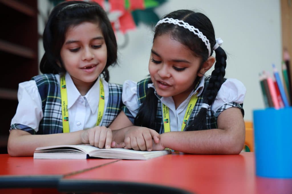 Two students reading together in class